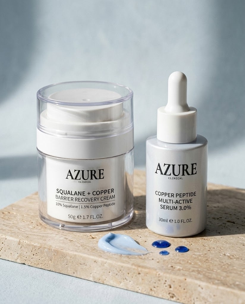The Azure Ritual, Azure Clinical copper peptide serum and barrier recovery cream together on travertine stone with blue serum drops